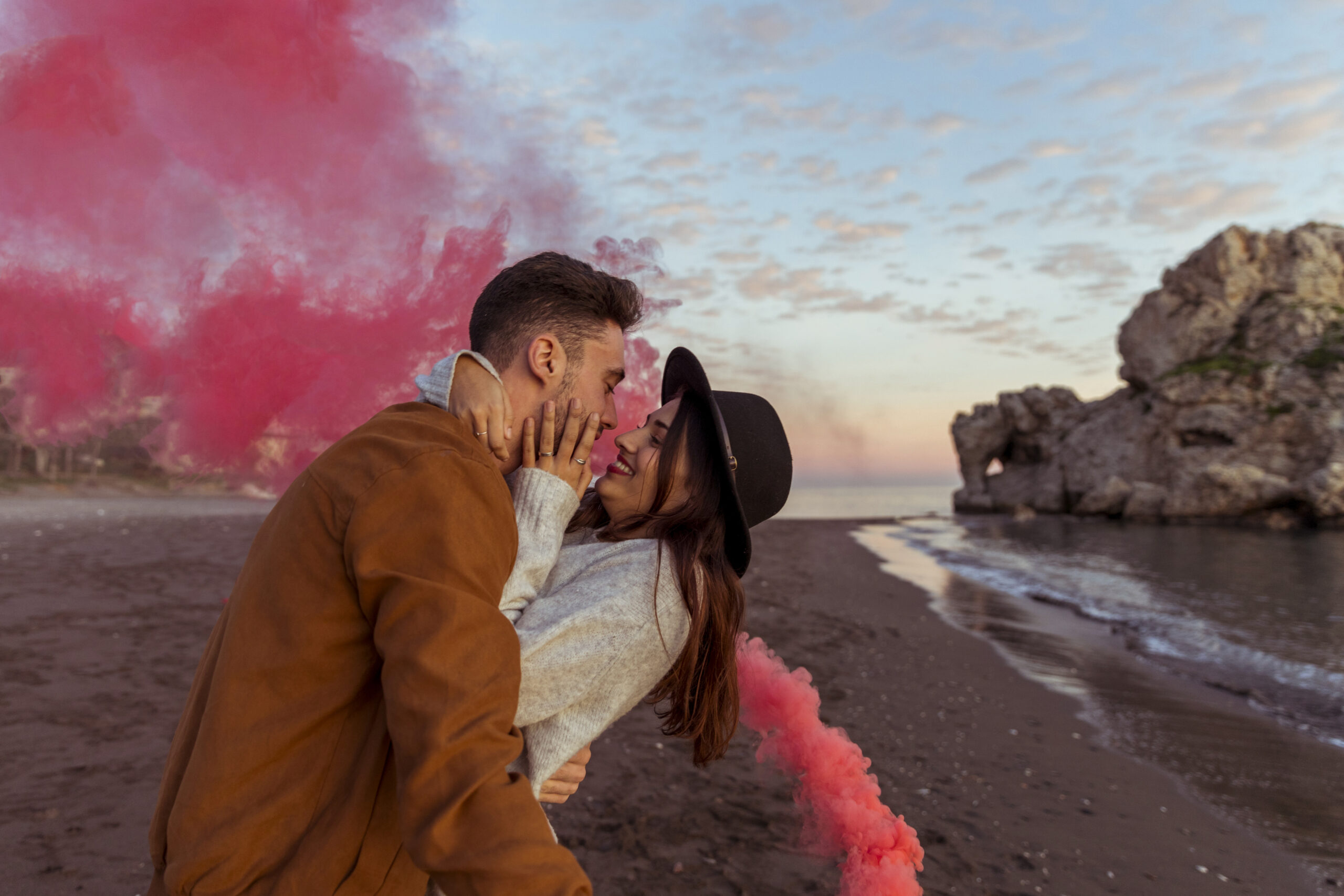 man-hugging-woman-with-smoke-bomb-sea-shore